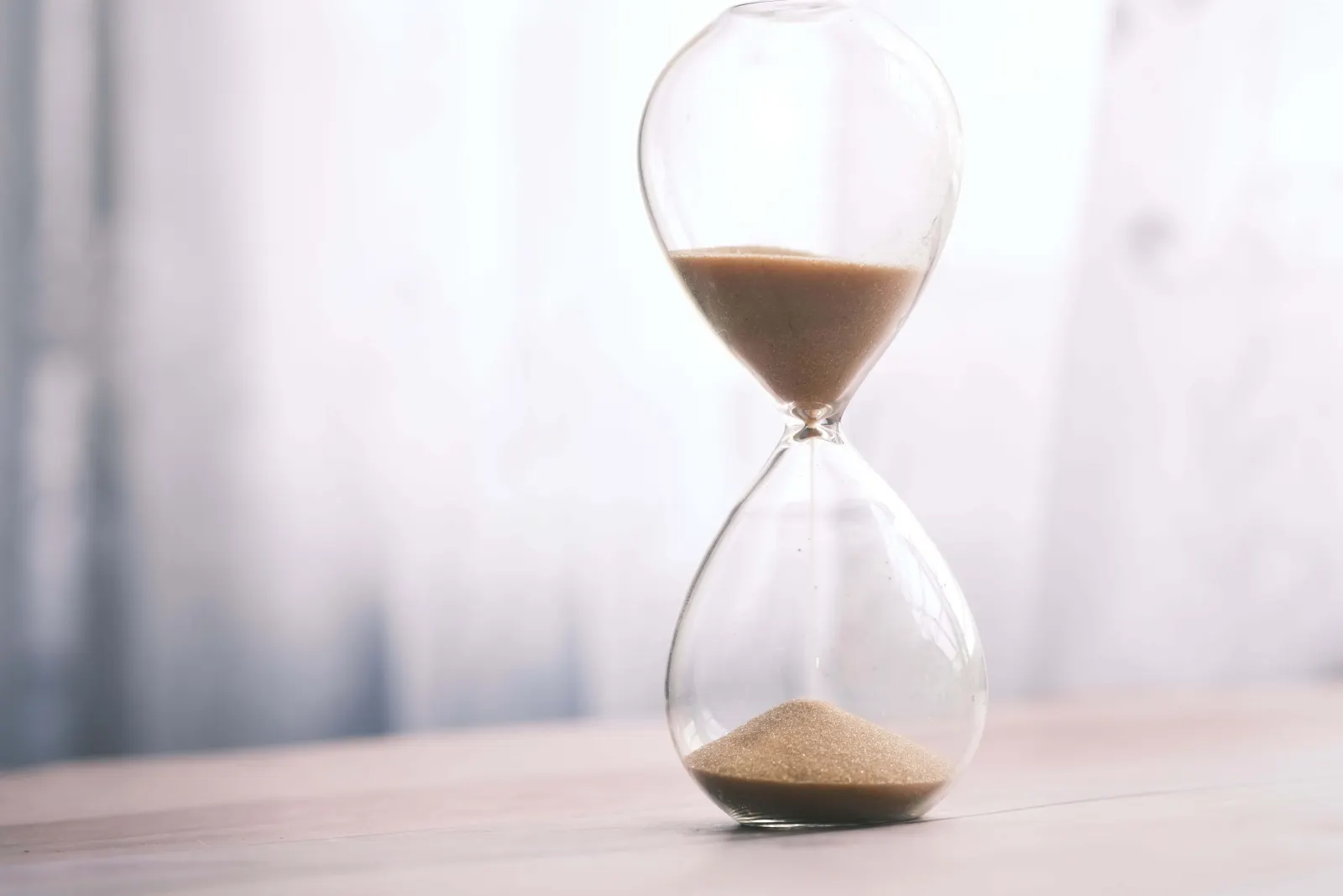 Hourglass on a desk representing time lost to paper care records.