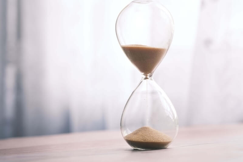 Hourglass on a desk representing time lost to paper care records.